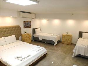 a hotel room with two beds and two tables at Amber Butik Otel in Çeşme