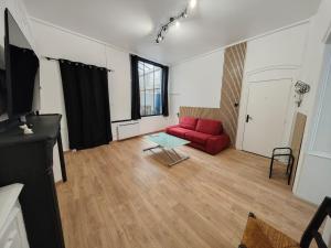 a living room with a red couch and a table at Le Cleyputz in Dunkerque