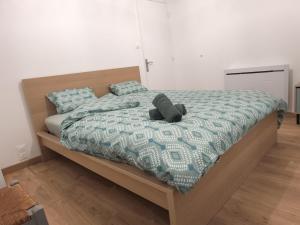 a teddy bear laying on a bed in a bedroom at Le Cleyputz in Dunkerque