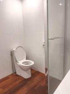 a bathroom with a toilet with a glass shower stall at Le Cleyputz in Dunkerque