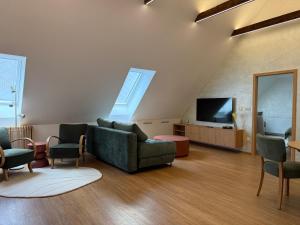 a living room with a couch and a tv at Apartmány u čalouníků in Litomyšl