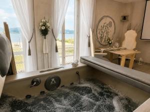 a bath tub filled with water in a room with a window at Hotel Butterfly in Torre del Lago Puccini +65 photos
