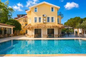 a villa with a swimming pool in front of a house at Güneş Boutique Hotel - Oludeniz in Oludeniz