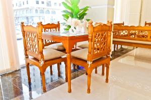 a dining room table with two chairs and a table at Alpha Suites Salalah in Salalah
