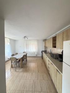a kitchen with a table and a dining room at Vila Mina in Ocnele Mari