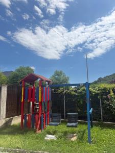 a playground in a yard with a fence at Vila Mina in Ocnele Mari