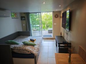 a bedroom with a bed and a large window at Nature stopover in green Provence in Artigues