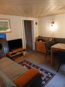 a living room with a couch and a tv and a table at Klein Hohe Fichten in Kurort Altenberg