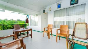 a room with chairs and tables and a balcony at lake Edge Dambulla in Dambulla