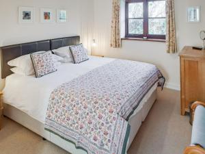 a bedroom with a large bed with a quilt on it at Jacks Barn - Hssu in Welcombe