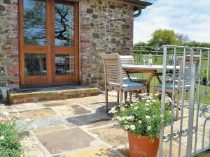 a patio with a table and chairs and a fence at Jacks Barn - Hssu in Welcombe +9 photos