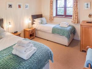 a bedroom with two beds with towels on them at Jacks Barn - Hssu in Welcombe