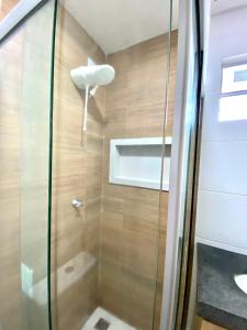 a shower with a glass door in a bathroom at 302 · 302 2qtos Encantador com garagem grátis in Belém