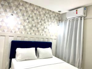 a bedroom with a bed with a blue headboard at 302 · 302 2qtos Encantador com garagem grátis in Belém