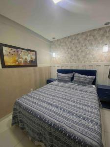 a bedroom with a bed with a blue and white comforter at 302 · 302 2qtos Encantador com garagem grátis in Belém +23 photos