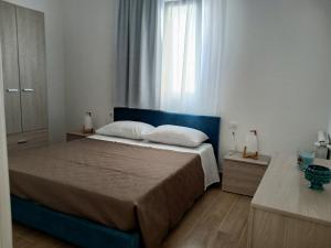 a bedroom with a large bed and a window at A Casuzza in Balestrate