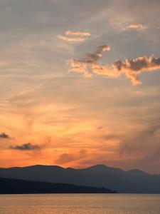 a sunset over the water with mountains in the background at A Casuzza in Balestrate +2 photos