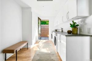 a kitchen with white cabinets and a bench at Spacious Luxury Villa in Copenhagen in Copenhagen