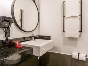 a bathroom with a white sink and a mirror at ibis Ribeirao Preto Vila do Golf Shopping in Ribeirão Preto +52 photos