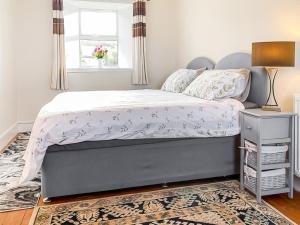 a bedroom with a bed and a window at Ballygroggan Cottage - Uk48768 in Machrihanish