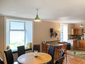a kitchen and dining room with a table and chairs at Ballygroggan Farmhouse - Uk35208 in Machrihanish