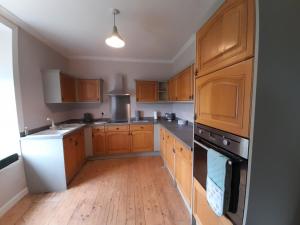 a kitchen with wooden cabinets and a white appliance at Ballygroggan Farmhouse - Uk35208 in Machrihanish +11 photos