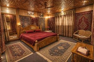 a bedroom with a bed and a table and a chair at Dilnaaz Group Of Houseboats in Srinagar