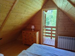 a bedroom with a bed and a window in a cabin at Chatka w gorach in Lewin Kłodzki