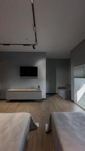 a white room with two beds and a flat screen tv at Готель «ТАВЕРНА» in Ovruch +8 photos