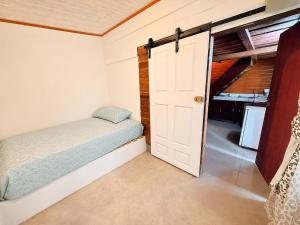 a small bedroom with a bed and a closet at Cabaña El Cafetal in Valle Hornito