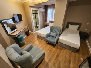 a small hotel room with a bed and a chair at ERSA Hotel in Tuzla