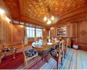 a dining room with a wooden table and chairs at Dilnaaz Group Of Houseboats in Srinagar