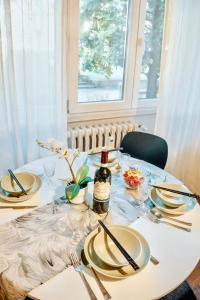 a table with plates and a bottle of wine on it at Zen Suite - 50m from Metro M1 - Direct to F1 Monza, Fashion Week, Duomo in Milan +15 photos