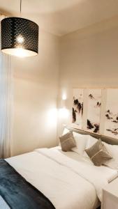 a bedroom with a large white bed and a lamp at Zen Suite - 50m from Metro M1 - Direct to F1 Monza, Fashion Week, Duomo in Milan