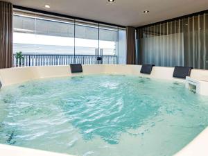 eine große Badewanne mit zwei Stühlen in einem Zimmer in der Unterkunft Novotel Criciuma in Criciúma
