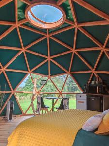 a room with a bed in a tent with a window at Le Havre de Chaux in La Bretenière