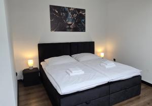 a bedroom with a bed with two towels on it at RG Apartments in Šamorín