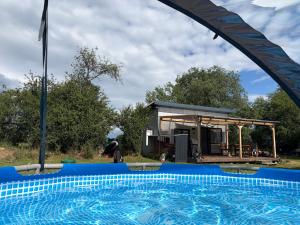 a swimming pool in front of a small house at Tiny house - Chatka v Řeži u Prahy in Husinec