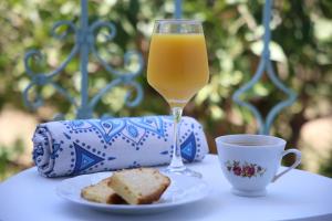a glass of orange juice next to a plate of bread at Apartment Simply 302 in Gázion