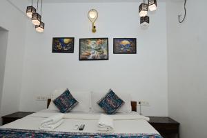 a bedroom with a bed with four pictures on the wall at Sarovar Morjim in Morjim
