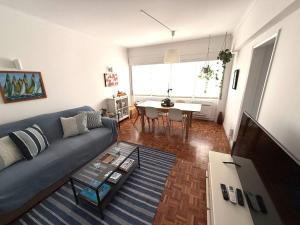 a living room with a blue couch and a table at Estoril 2 bd by the Beach in Estoril