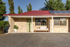 a house with a bed and a solar roof at Amadiya Port Arthur Villas in Port Arthur