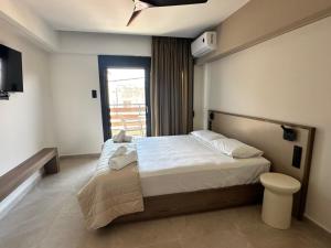 a bedroom with a large bed and a balcony at 7 Suites in Skiathos