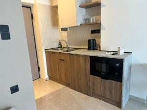 a kitchen with a sink and a microwave at 7 Suites in Skiathos