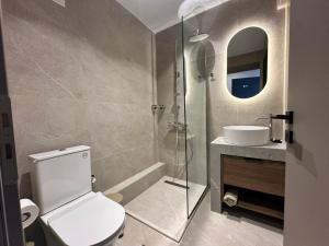 a bathroom with a toilet and a sink and a shower at 7 Suites in Skiathos +7 photos