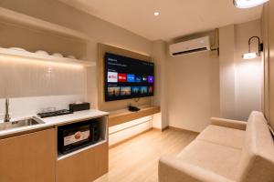 a kitchen with a couch and a tv in a room at The Bentley Hotel in Bangkok +83 photos