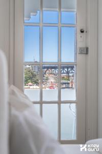 a window with a view of the roller coaster at KozyGuru | MacMahons Point | Harbour Hideaway in Sydney