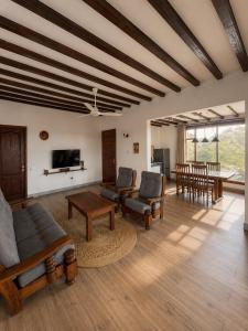 a living room with a couch and chairs and a tv at Malcom Ocean View Retreat in Pongwe