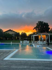 a swimming pool with a sunset in the background at Tenuta Paino in Sessa Aurunca