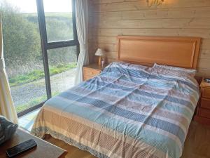 a bedroom with a bed and a large window at The Brown House in Woolfardisworthy